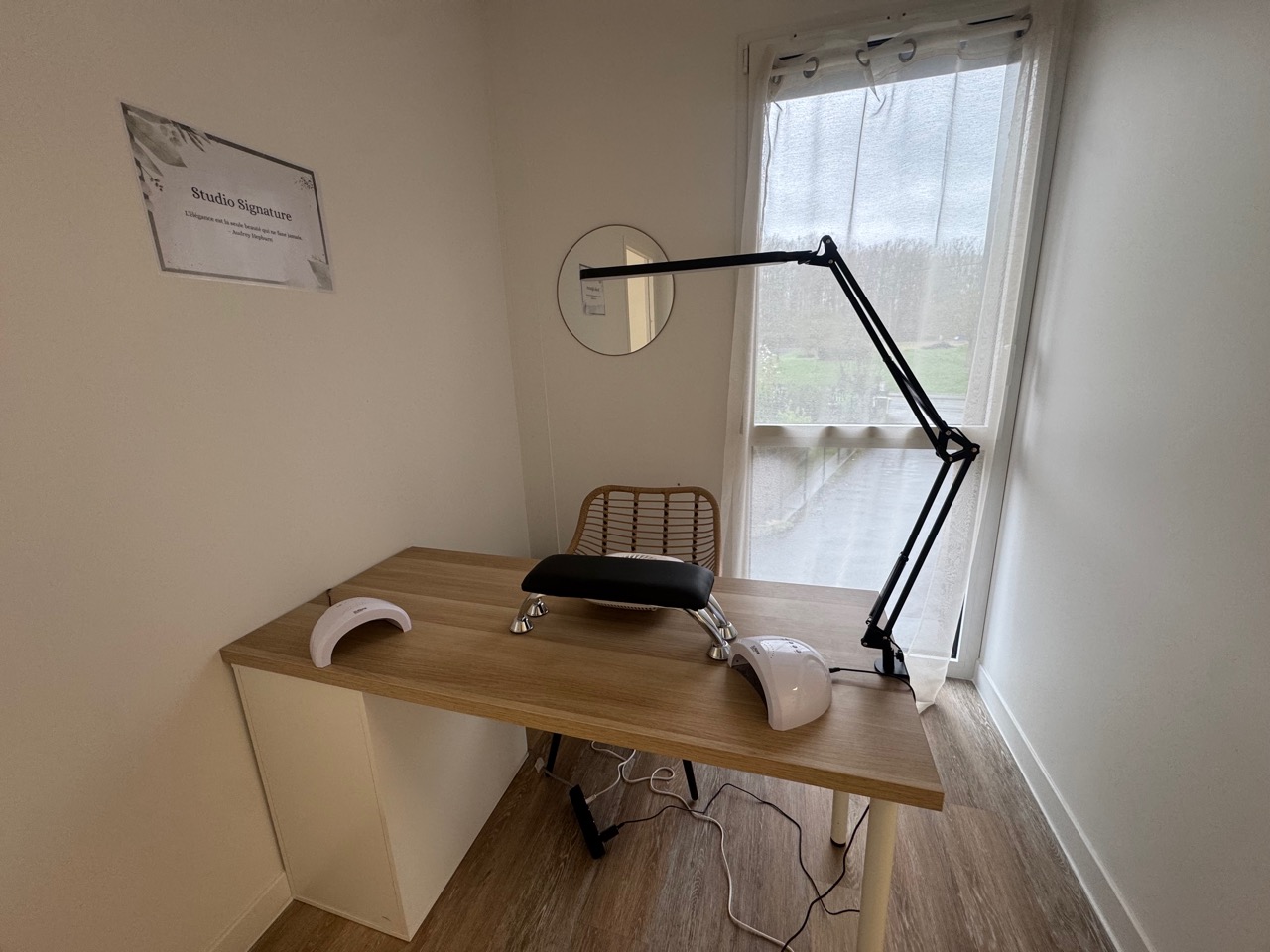 Petit bureau fermé : plan de travail en bois, lampe articulée et fenêtre donnant sur la verdure