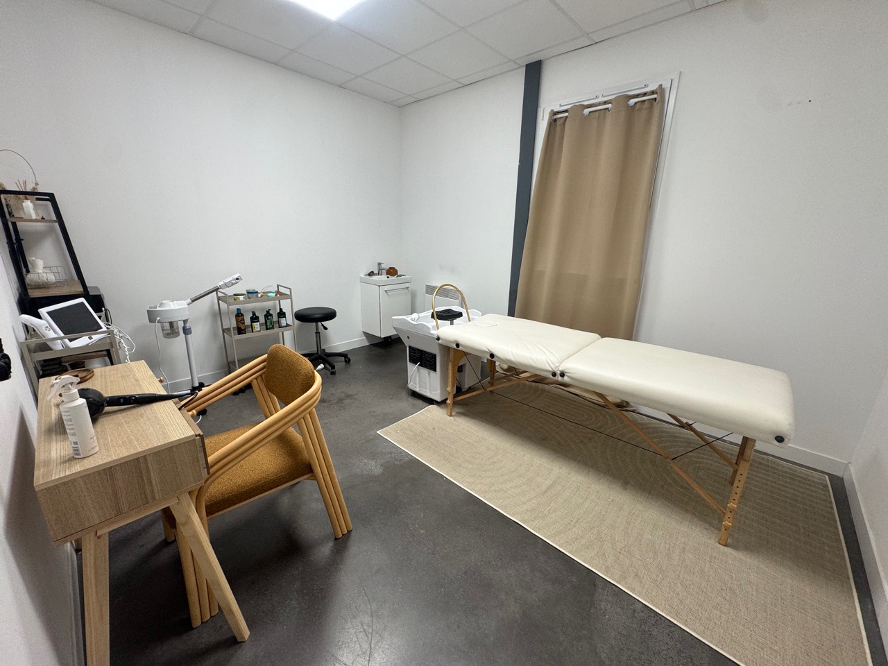 Salle claire équipée d’une table de soin, d’un bureau et d’un fauteuil